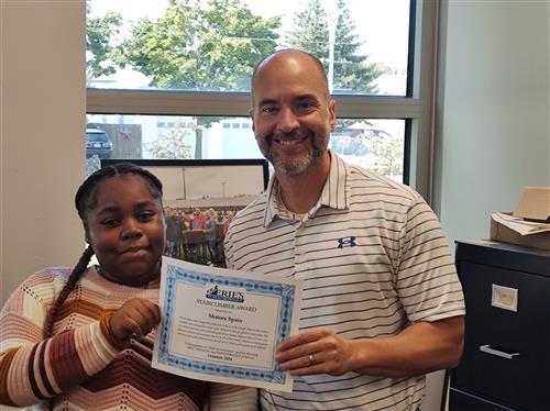 Shatora Spain, Erie High's October Stairclimber, poses with her certificate and Principal Don Orlando.